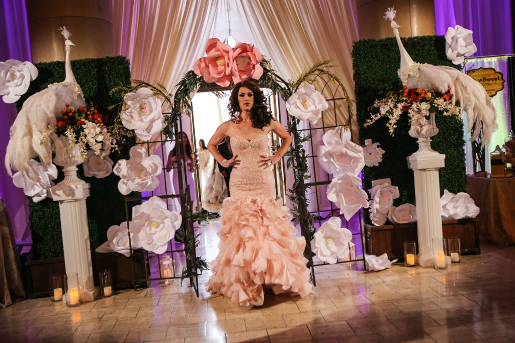 Wedding guest at vanity wedding show in front of flower and statue installation 
