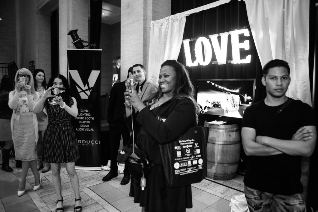 Crowd talking pictured with LOVE light signage and drapery in the background
