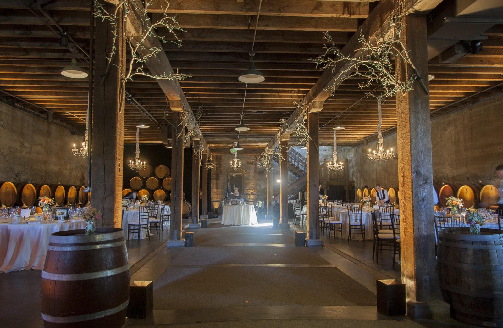 Indoor chandelier and up lighting for dining set-up in winery